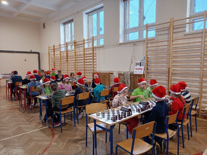 II Mikołajkowy Turniej Szachowy - dzieci siedzą przy stolikach i grają w szachy